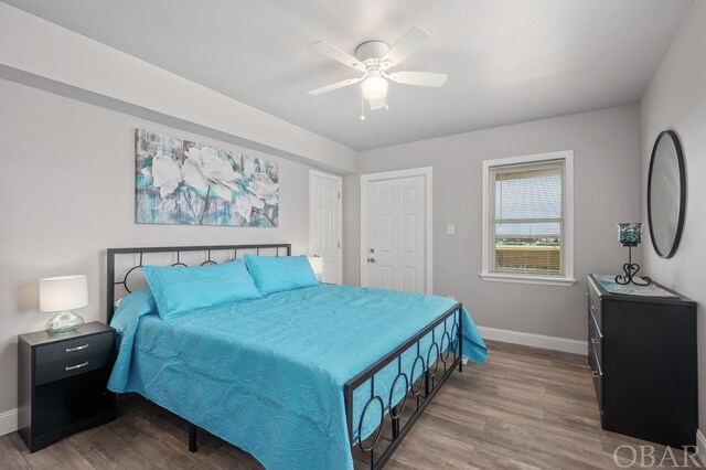 bedroom with ceiling fan, baseboards, and wood finished floors