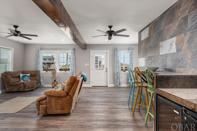 living room featuring beverage cooler, wood finished floors, beam ceiling, and baseboards