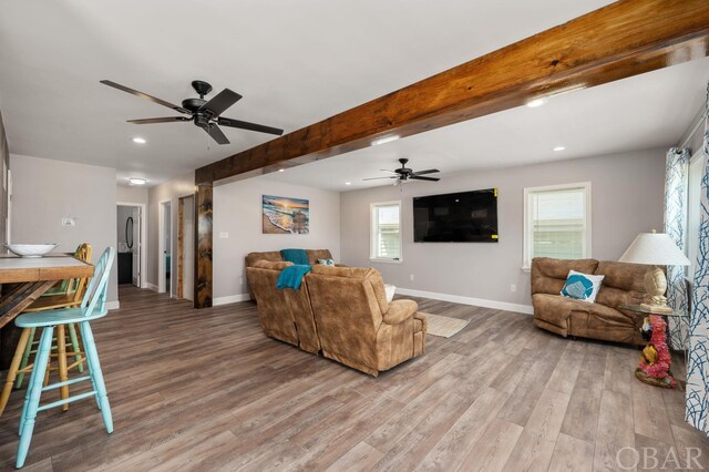 living room featuring beamed ceiling, recessed lighting, wood finished floors, and baseboards