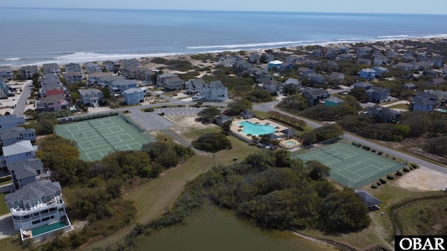 bird's eye view with a water view, a view of the beach, and a residential view