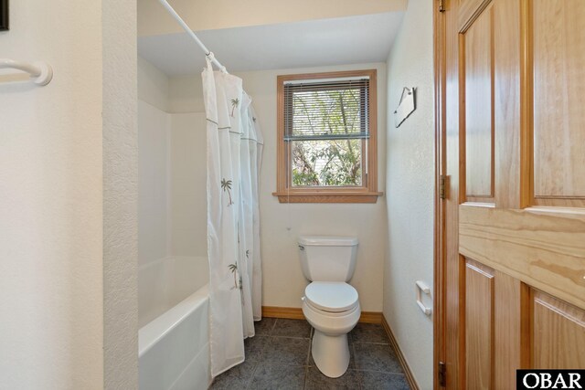 full bath featuring shower / bath combo, toilet, baseboards, and tile patterned floors