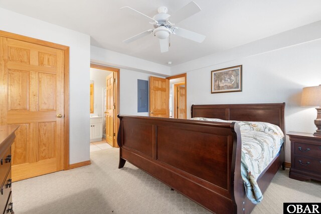 bedroom featuring light carpet, ceiling fan, baseboards, and ensuite bathroom