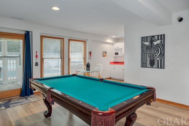 game room with plenty of natural light, light wood-style flooring, visible vents, and baseboards