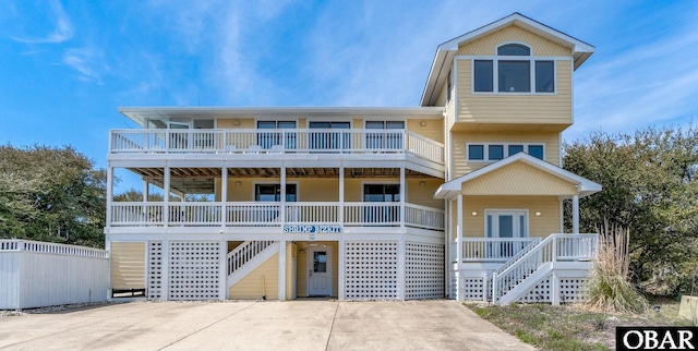 beach home featuring covered porch, stairway, and french doors