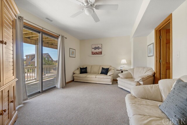 living area with carpet floors, visible vents, baseboards, and a ceiling fan