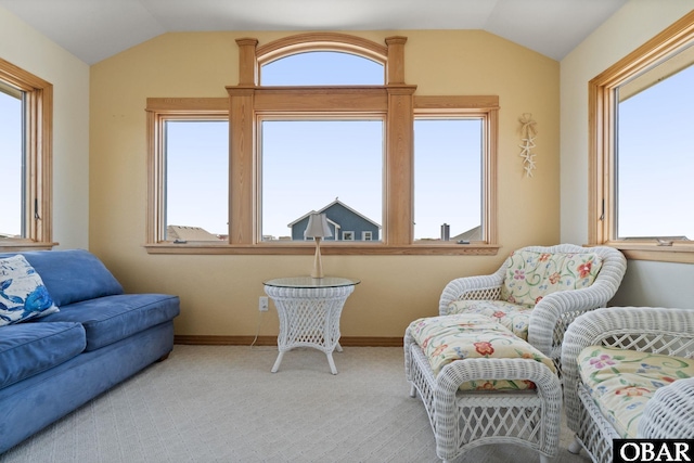 living area with lofted ceiling, plenty of natural light, and carpet