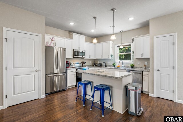 102 Prince Charles Ct Lot 47, Kill Devil Hills, NC 27948 - kitchen featuring stainless steel appliances, dark wood-style floors, white cabinets, a kitchen island, and recessed lighting