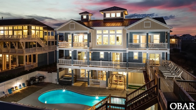 909 Lighthouse Dr Lot # 8, Corolla, NC 27927 - back of property at dusk with a balcony, a standing seam roof, stairs, a metal roof, and board and batten siding