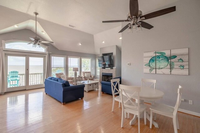 1386B Duck Rd Lot 34, Duck, NC 27949 - living room featuring lofted ceiling, a tile fireplace, light wood finished floors, visible vents, and a ceiling fan