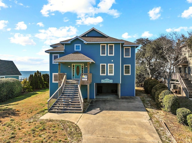 view of front of home featuring a carport, covered porch, driveway, and stairs