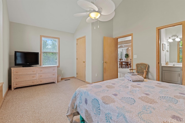 bedroom featuring ensuite bathroom, high vaulted ceiling, light carpet, a sink, and baseboards