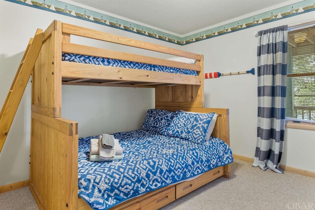 bedroom featuring carpet, baseboards, and a textured ceiling