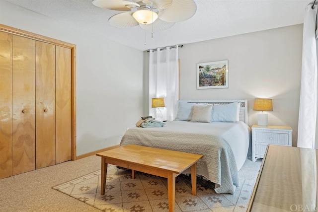 carpeted bedroom with a ceiling fan and a textured ceiling