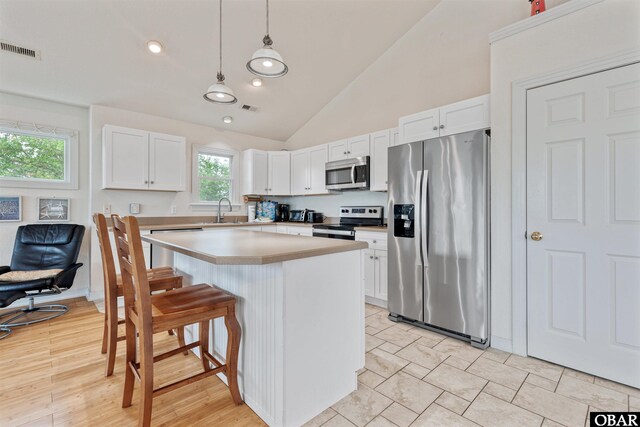 759 Ridge Point Dr Lot 42, Corolla, NC 27927 - kitchen featuring stainless steel appliances, a sink, vaulted ceiling, white cabinetry, and recessed lighting