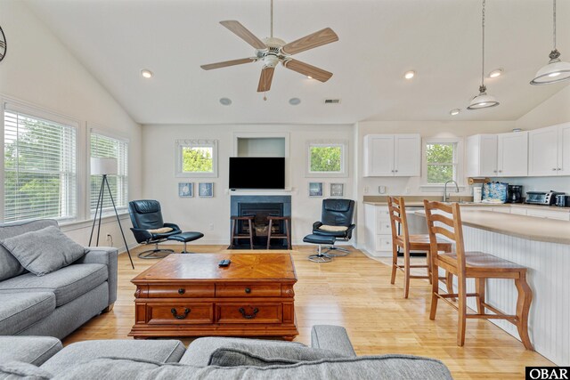 759 Ridge Point Dr Lot 42, Corolla, NC 27927 - living area with vaulted ceiling, light wood finished floors, a fireplace with flush hearth, ceiling fan, and recessed lighting