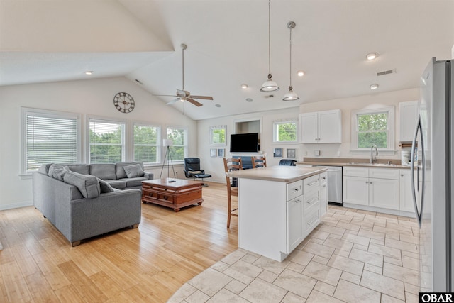759 Ridge Point Dr Lot 42, Corolla, NC 27927 - kitchen featuring open floor plan, appliances with stainless steel finishes, white cabinets, a breakfast bar area, and high vaulted ceiling