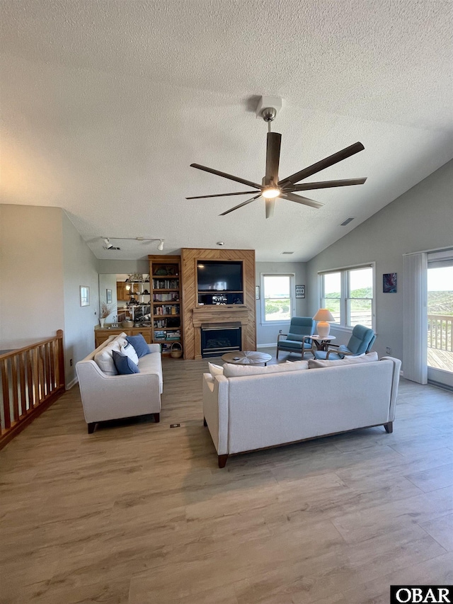 25273 Sea Isle Hills Dr Lot 5-2, Waves, NC 27982 - living area featuring a textured ceiling, light wood-style flooring, a ceiling fan, a large fireplace, and lofted ceiling
