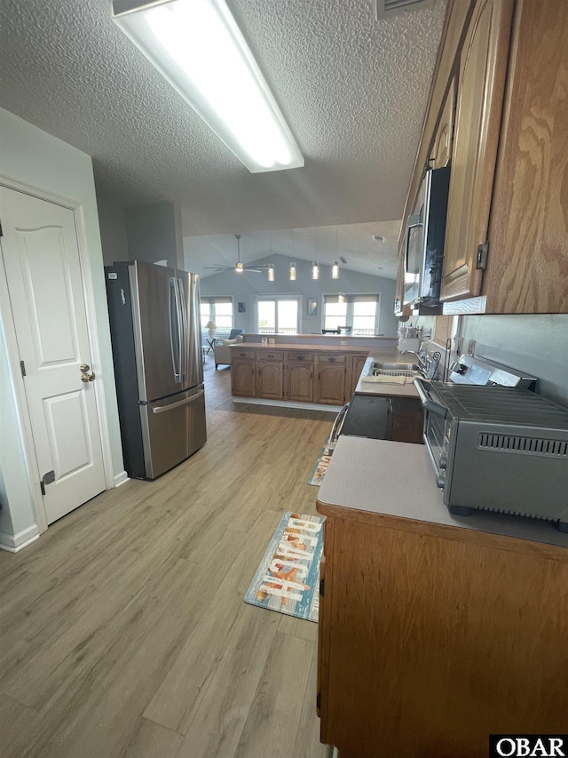 25273 Sea Isle Hills Dr Lot 5-2, Waves, NC 27982 - kitchen with appliances with stainless steel finishes, a textured ceiling, light wood finished floors, brown cabinetry, and a peninsula