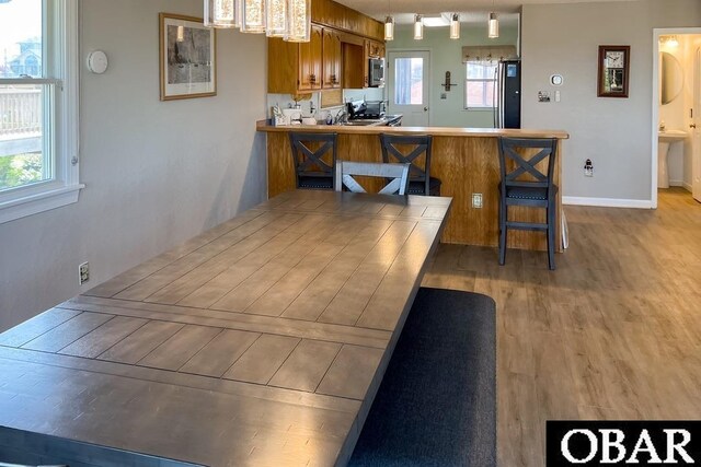 25273 Sea Isle Hills Dr Lot 5-2, Waves, NC 27982 - kitchen with brown cabinets, fridge, wood finished floors, stainless steel microwave, and a peninsula