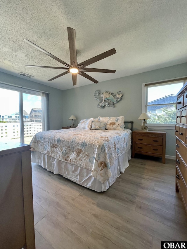 25273 Sea Isle Hills Dr Lot 5-2, Waves, NC 27982 - bedroom with multiple windows, wood finished floors, a textured ceiling, and a ceiling fan