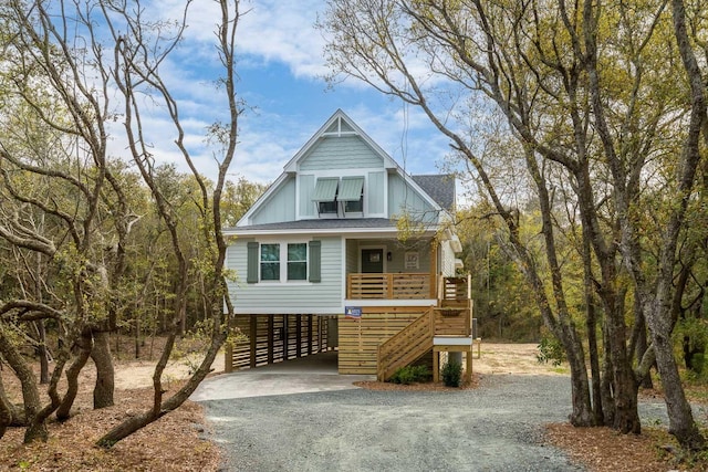 view of front facade with driveway, a carport, covered porch, and board and batten siding