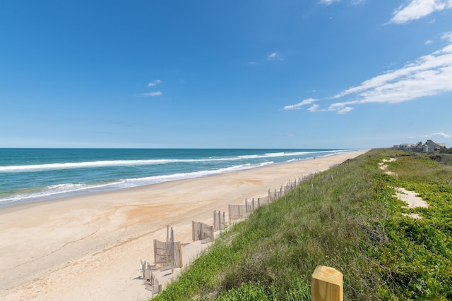 water view featuring a beach view and fence