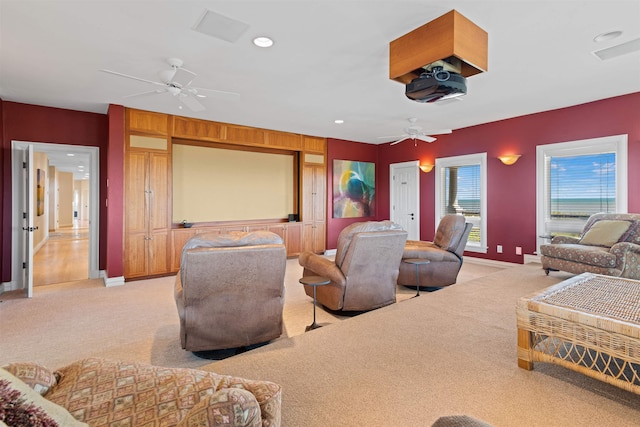 home theater with baseboards, a ceiling fan, and light colored carpet