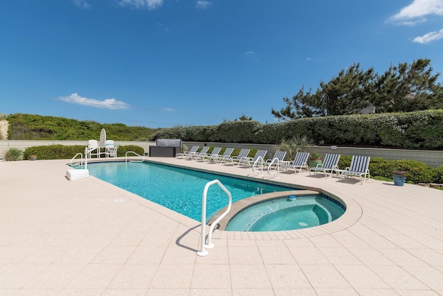 view of pool featuring a patio, fence, a fenced in pool, and an in ground hot tub