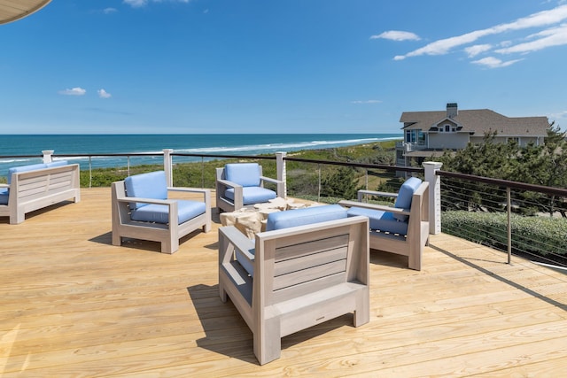 wooden deck with a water view, outdoor lounge area, and a view of the beach