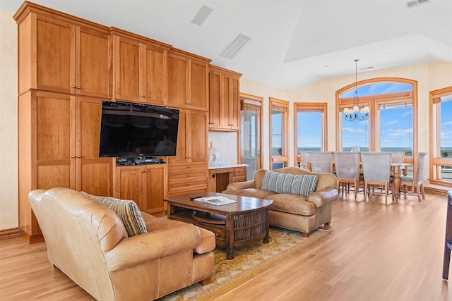 living area featuring a chandelier, lofted ceiling, visible vents, and light wood finished floors