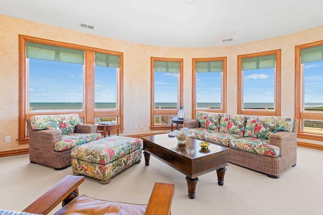 living room featuring visible vents, a water view, and baseboards