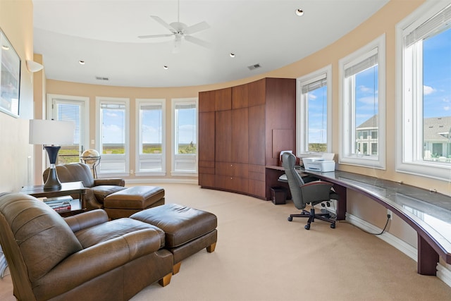 office space featuring a wealth of natural light, visible vents, and light carpet