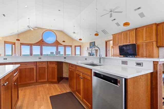 kitchen with light countertops, a sink, hanging light fixtures, and stainless steel dishwasher