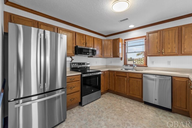 50096 Freebooter Ct Lot 178, Frisco, NC 27936 - kitchen featuring a sink, stainless steel appliances, brown cabinetry, and light countertops
