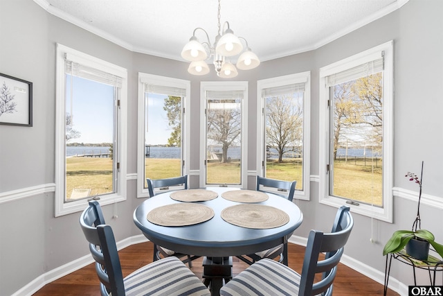 dining space featuring baseboards, a notable chandelier, wood finished floors, and ornamental molding