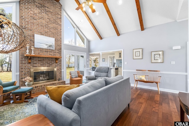 living room featuring dark wood-style flooring, high vaulted ceiling, beamed ceiling, ceiling fan, and a fireplace