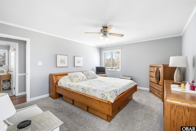 carpeted bedroom featuring baseboards, ceiling fan, and crown molding