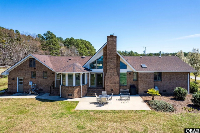 rear view of property featuring a lawn, crawl space, entry steps, brick siding, and a chimney