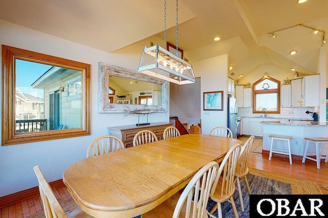 dining space with lofted ceiling, light wood-style floors, and recessed lighting