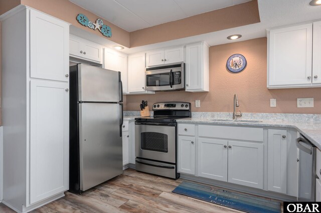8123 S Old Oregon Inlet Rd Unit 208, Nags Head, NC 27959 - kitchen with appliances with stainless steel finishes, a sink, white cabinetry, recessed lighting, and light wood-style floors