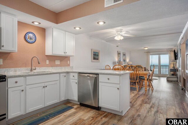 8123 S Old Oregon Inlet Rd Unit 208, Nags Head, NC 27959 - kitchen with a sink, stainless steel dishwasher, a peninsula, light wood-style flooring, and white cabinetry