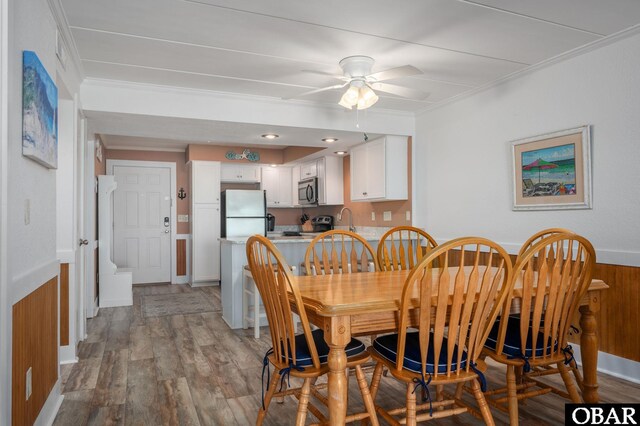 8123 S Old Oregon Inlet Rd Unit 208, Nags Head, NC 27959 - dining room featuring wood finished floors, a ceiling fan, and ornamental molding