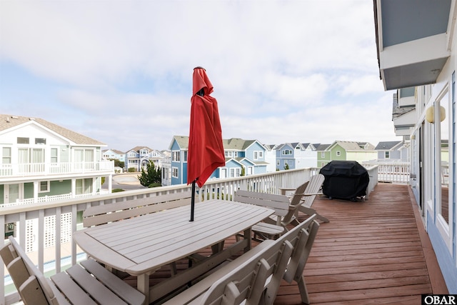 deck featuring a residential view, grilling area, and outdoor dining space