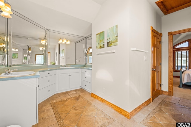 ensuite bathroom featuring connected bathroom, a sink, and baseboards