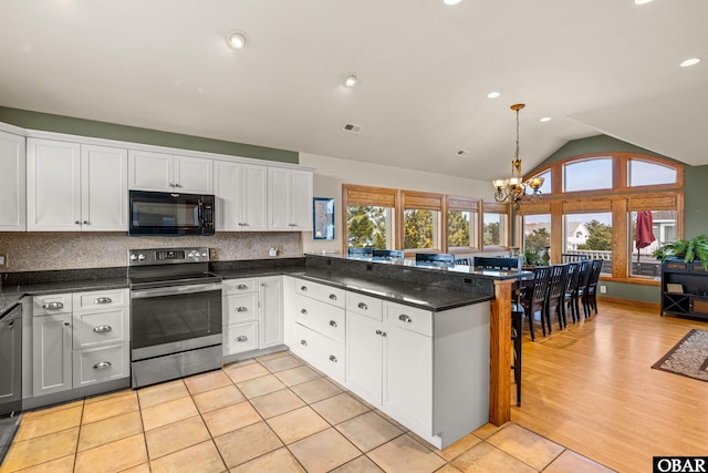 kitchen featuring tasteful backsplash, an inviting chandelier, stainless steel range with electric cooktop, white cabinetry, and black microwave