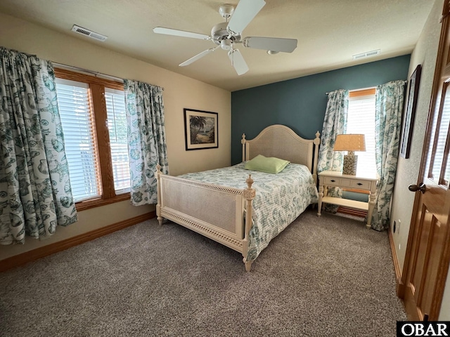 bedroom featuring dark colored carpet, a ceiling fan, visible vents, and baseboards