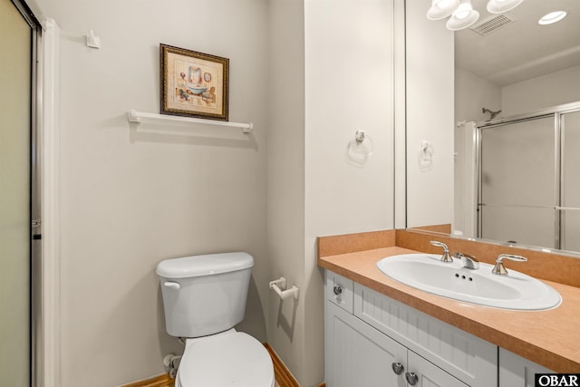 bathroom with visible vents, a shower with door, vanity, and toilet