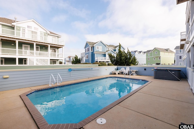 view of pool featuring a fenced in pool, a residential view, and a patio area