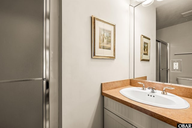 bathroom with toilet, visible vents, a stall shower, and vanity