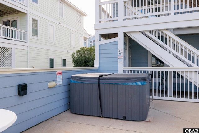 view of patio / terrace featuring central air condition unit, a hot tub, and stairs